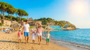 Famiglia che passeggia sulla spiaggia con attrazioni turistiche italiane sullo sfondo